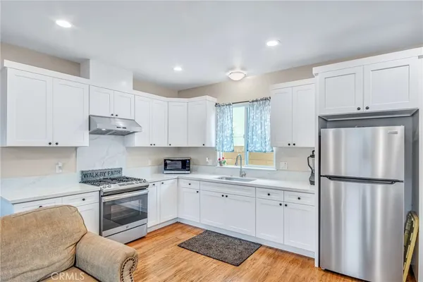 a kitchen with white cabinets and stainless steel appliances