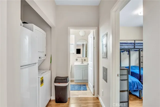 a view of hallway with wooden floor and bathroom