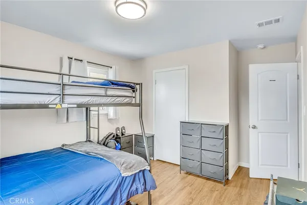 a bedroom with a bed and wooden floor