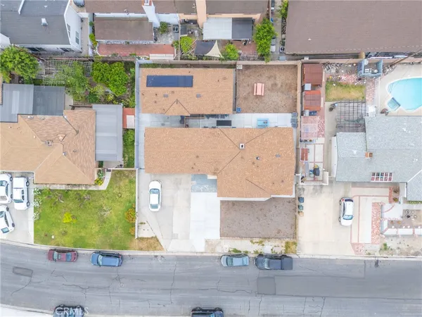 an aerial view of residential houses with outdoor space and parking