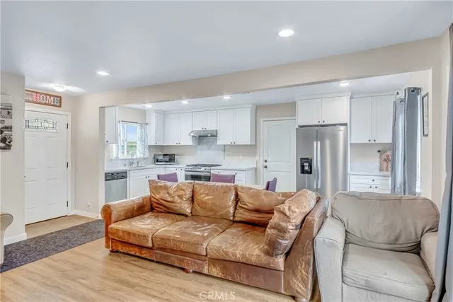 a living room with stainless steel appliances kitchen island granite countertop furniture and a couch