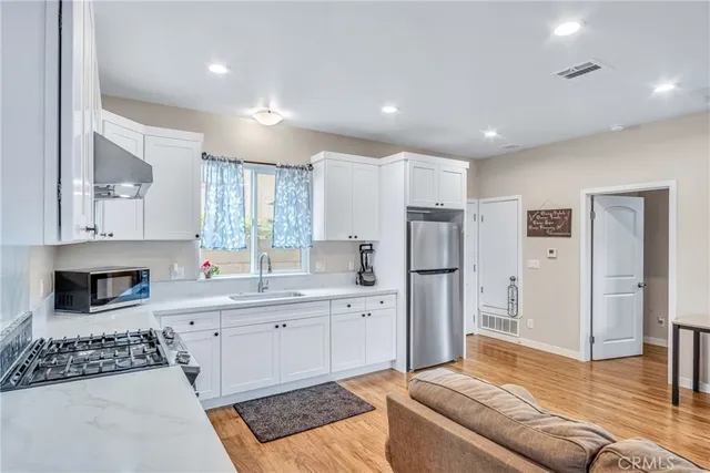 a kitchen with white cabinets and stainless steel appliances