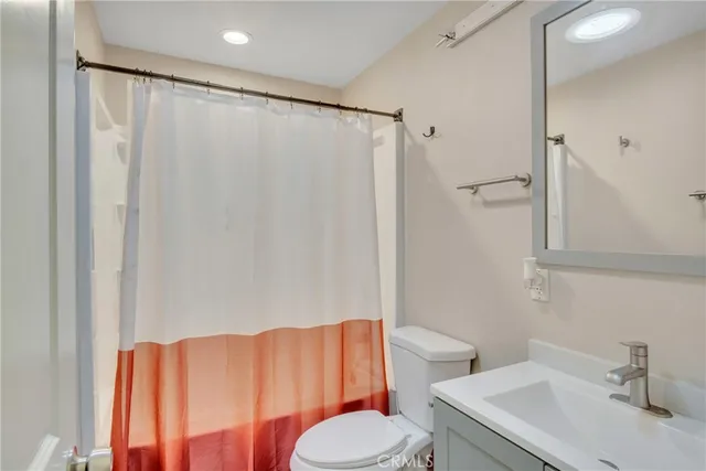 a bathroom with a sink a toilet and shower curtain