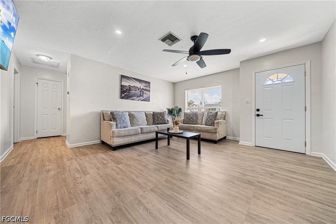 2335 50th Terrace Southwest Naples, FL 34116 - Photo 3 of 26 a living room with furniture and a wooden floor