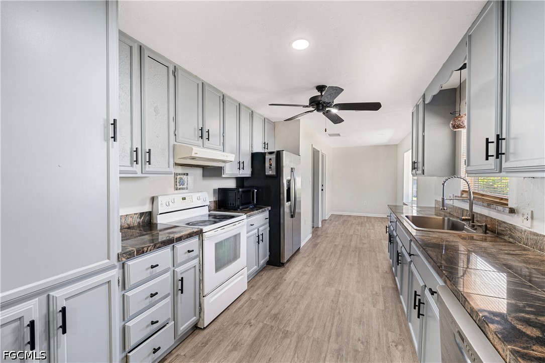 2335 50th Terrace Southwest Naples, FL 34116 - Photo 5 of 26 a kitchen with stainless steel appliances granite countertop a sink stove and refrigerator