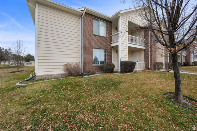 2095 South Main Street, Unit 13 Bountiful, UT 84010 - Photo 26 of 45 Back of house with a balcony, brick siding, and a yard