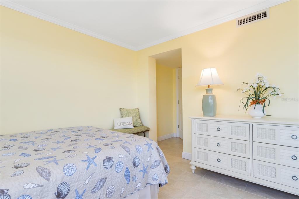 8767 Midnight Pass Road, Unit 101F Sarasota, FL 34242 - Photo 28 of 63 a bedroom with a bed and a lamp on dresser