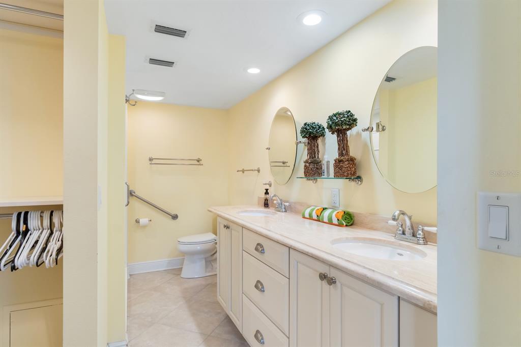 8767 Midnight Pass Road, Unit 101F Sarasota, FL 34242 - Photo 29 of 63 a spacious bathroom with a double vanity sink toilet and a mirror
