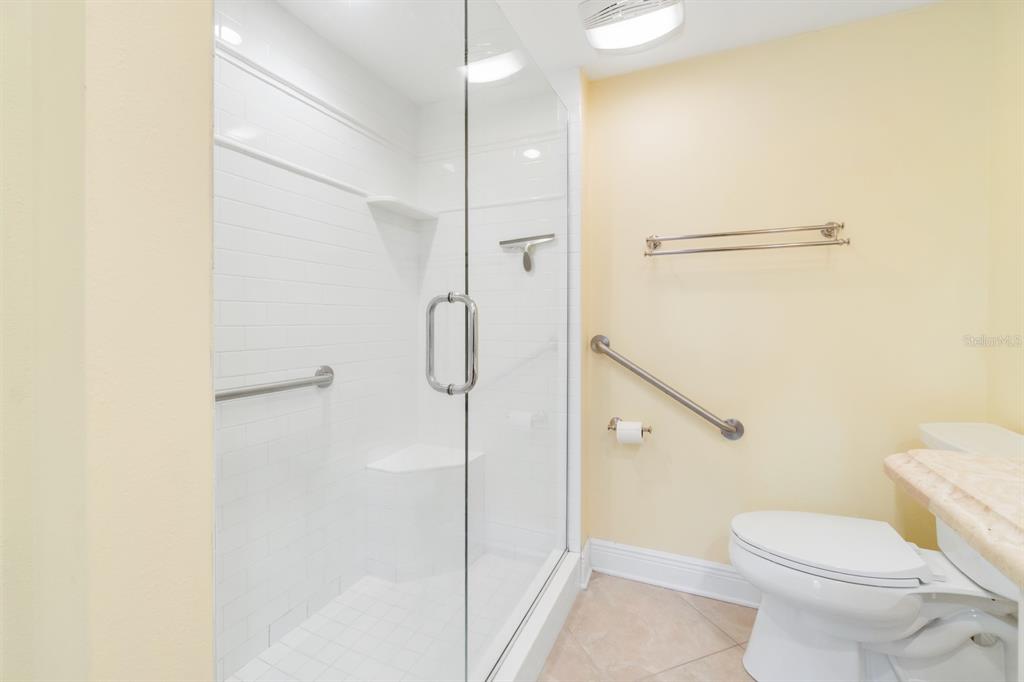 8767 Midnight Pass Road, Unit 101F Sarasota, FL 34242 - Photo 31 of 63 a bathroom with a shower and a toilet