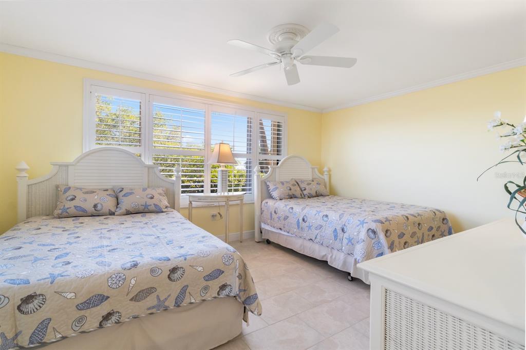 8767 Midnight Pass Road, Unit 101F Sarasota, FL 34242 - Photo 32 of 63 a bedroom with a large bed and a window
