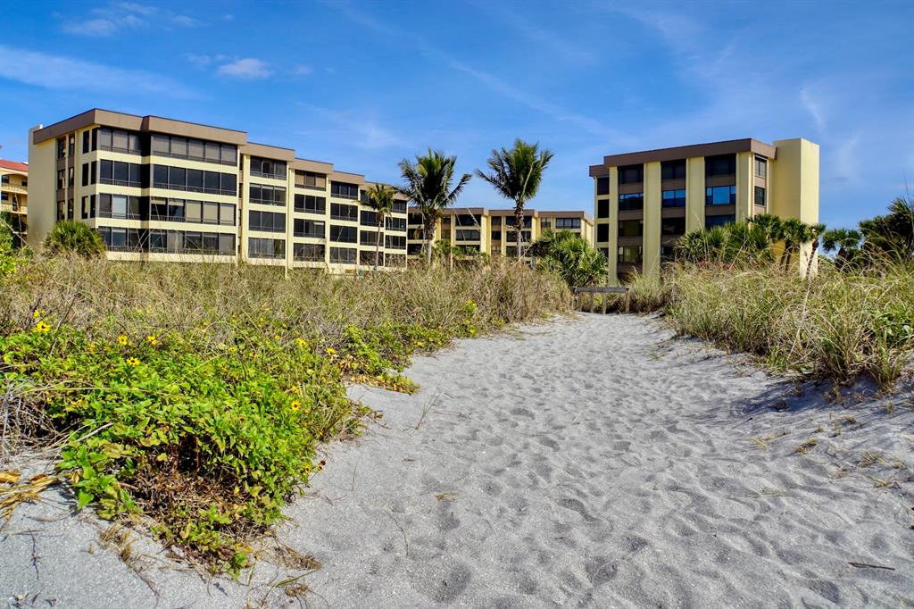 8767 Midnight Pass Road, Unit 101F Sarasota, FL 34242 - Photo 57 of 63 a front view of a house with a yard