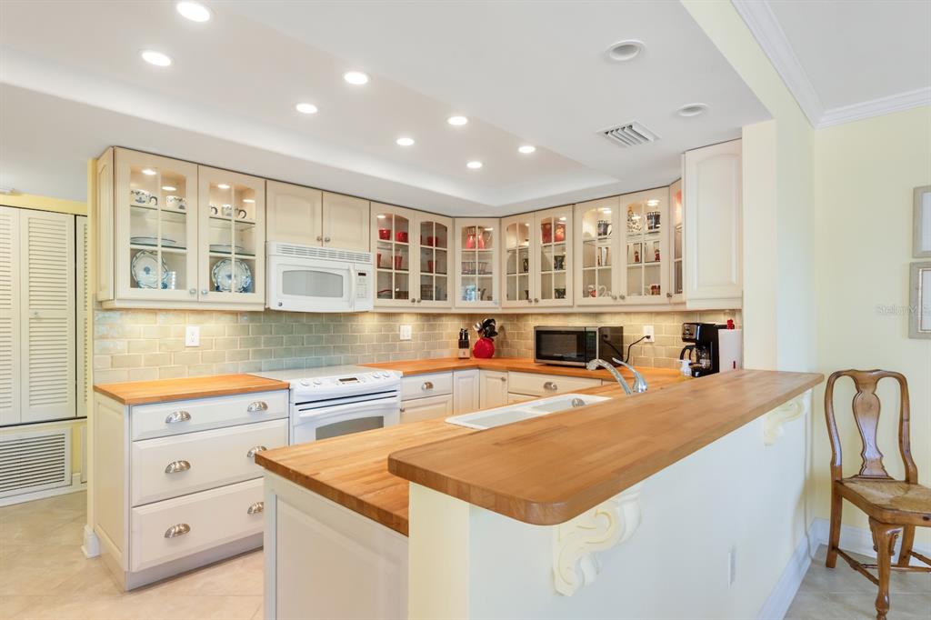 8767 Midnight Pass Road, Unit 101F Sarasota, FL 34242 - Photo 7 of 63 a kitchen with stainless steel appliances granite countertop a stove and a refrigerator