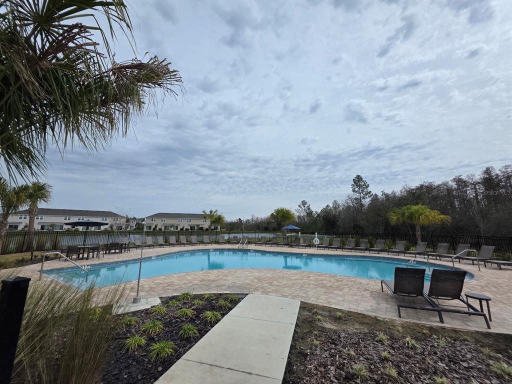 3318 Composition Street Kissimmee, FL 34758 - Photo 23 of 28 a view of a lake with a bench and trees in the background