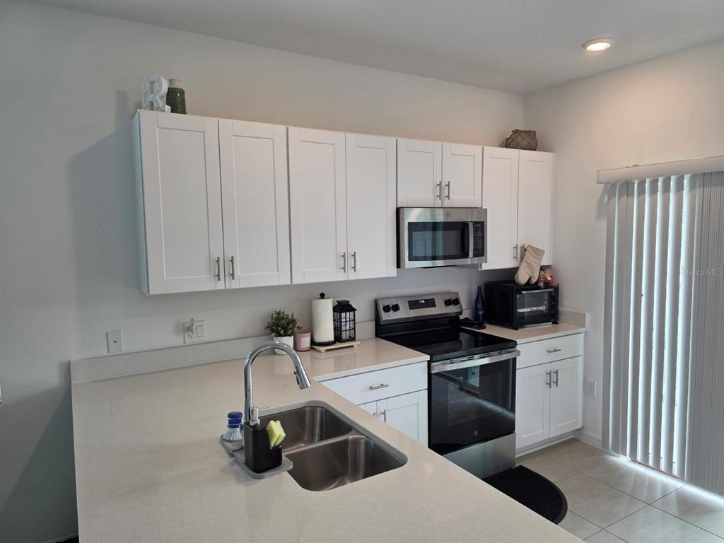 3318 Composition Street Kissimmee, FL 34758 - Photo 7 of 28 a kitchen with a sink a stove and cabinets