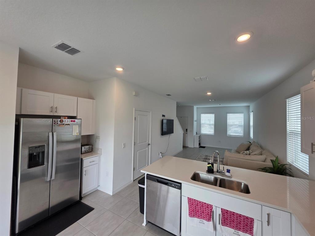 3318 Composition Street Kissimmee, FL 34758 - Photo 9 of 28 a kitchen with kitchen island a sink stove and refrigerator