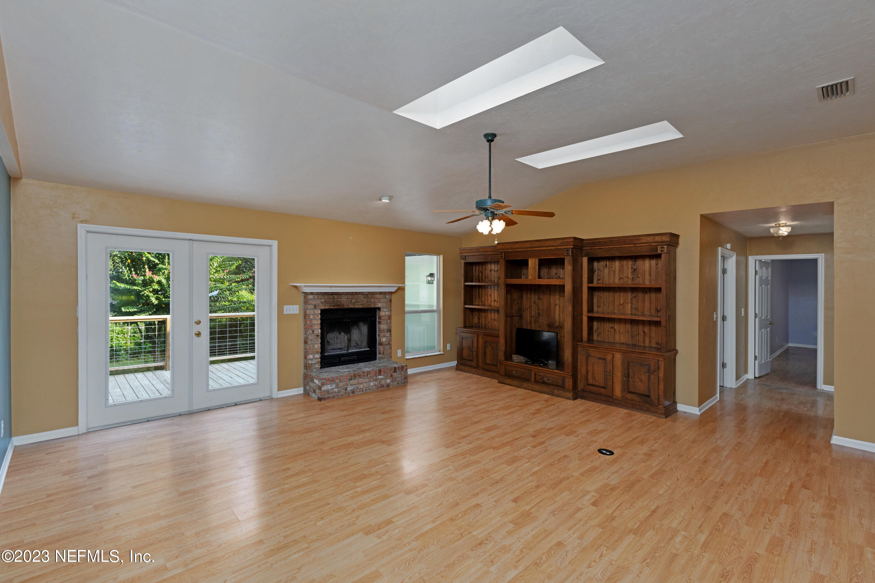 445 Southeast 28th Loop Melrose, FL 32666 - Photo 11 of 75 an empty room with wooden floor a fireplace and window