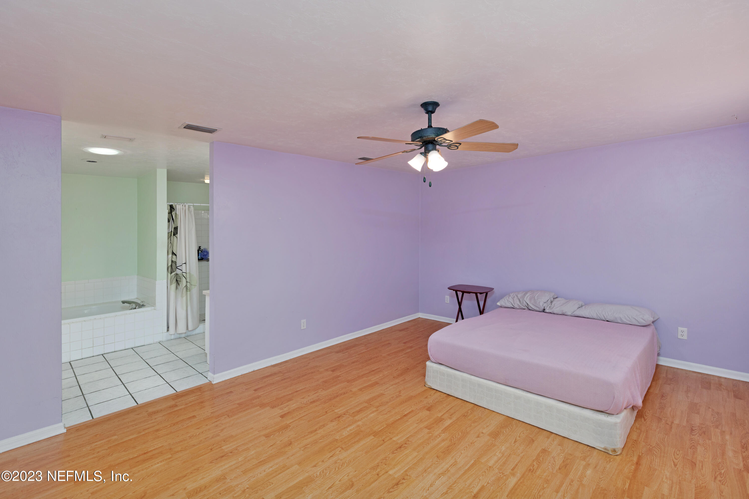 445 Southeast 28th Loop Melrose, FL 32666 - Photo 19 of 75 a bedroom with a bed and a chandelier