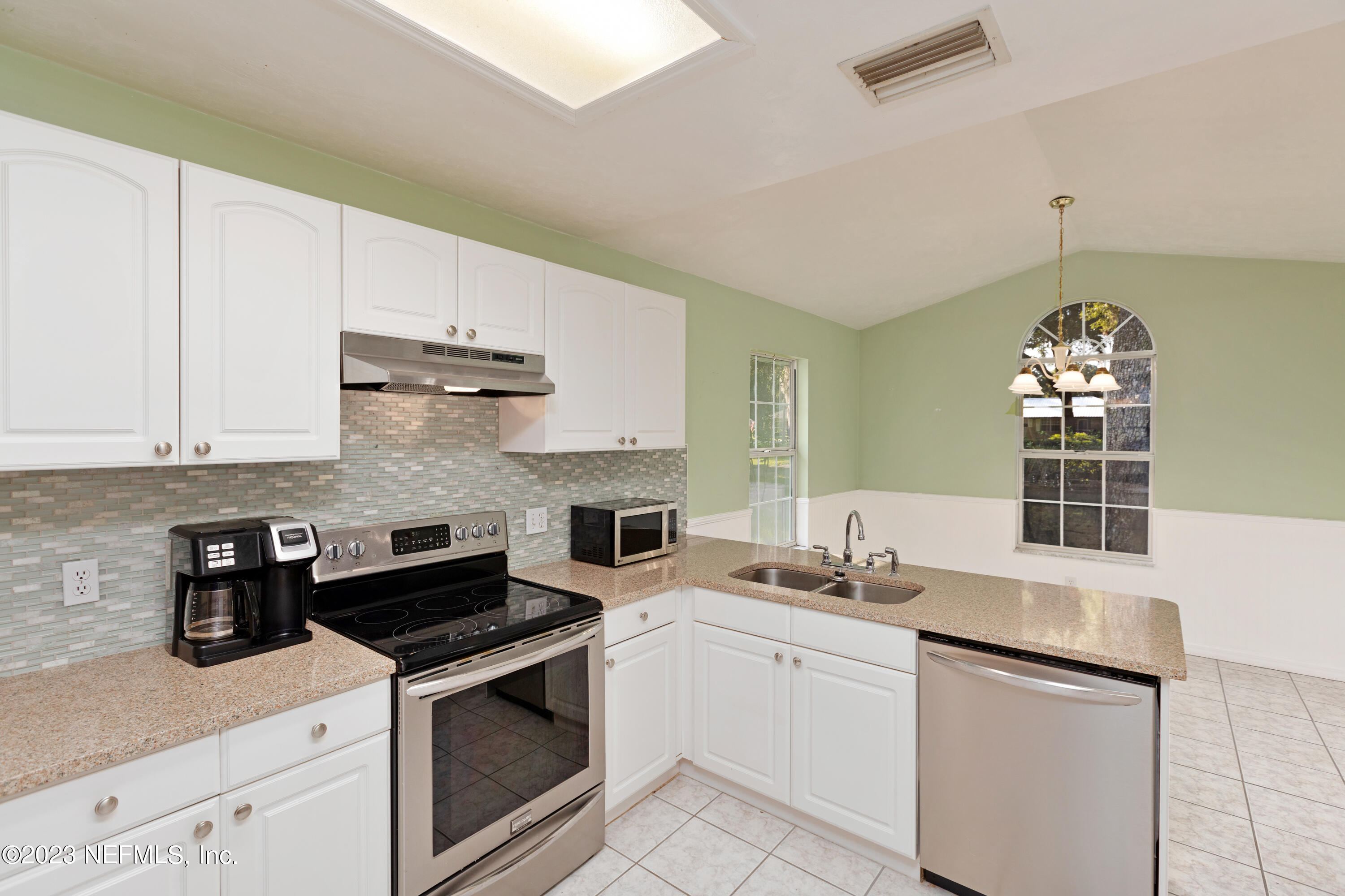 445 Southeast 28th Loop Melrose, FL 32666 - Photo 29 of 75 a kitchen with stainless steel appliances granite countertop a sink stove oven and white cabinets