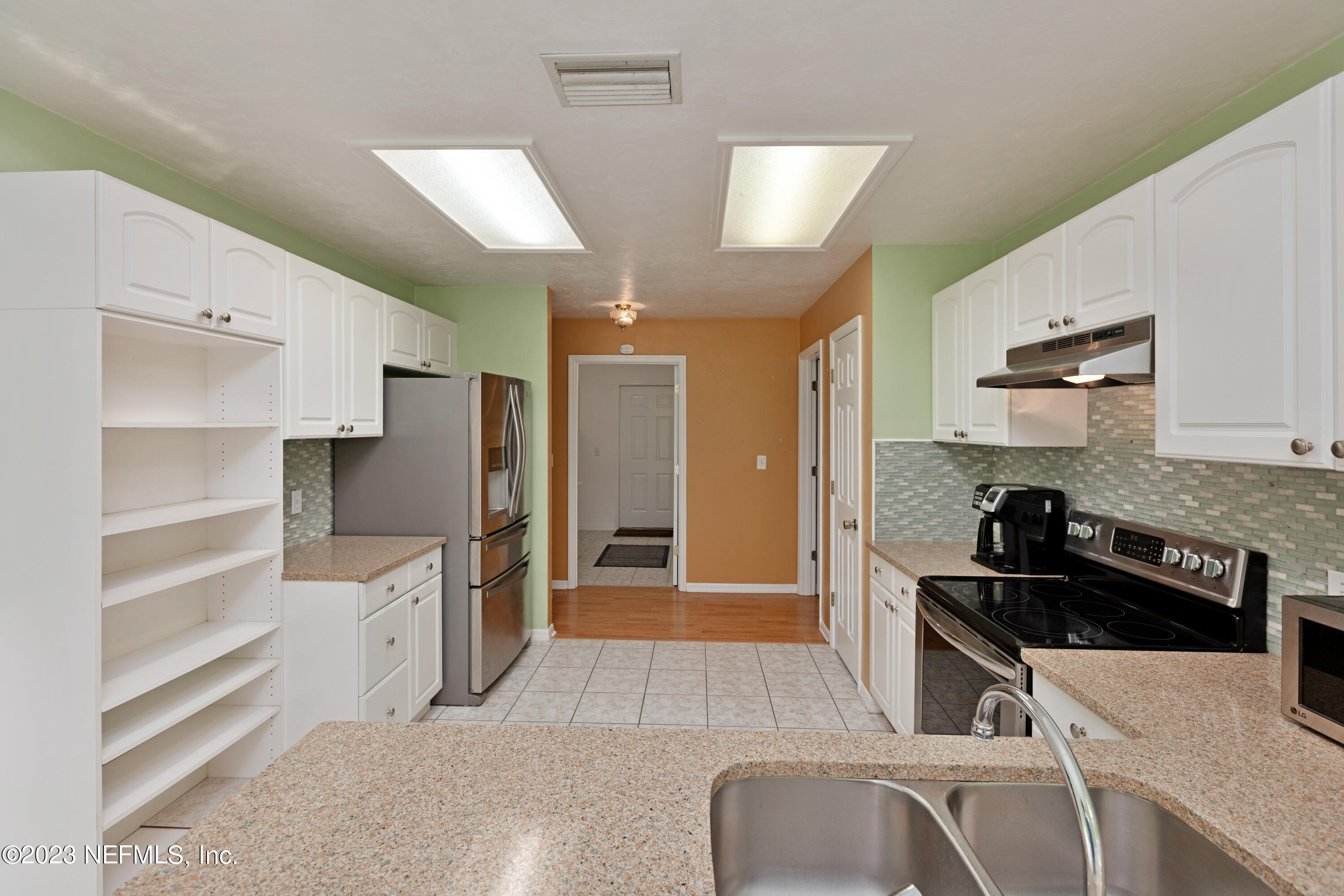 445 Southeast 28th Loop Melrose, FL 32666 - Photo 33 of 75 a kitchen with granite countertop a refrigerator and a sink