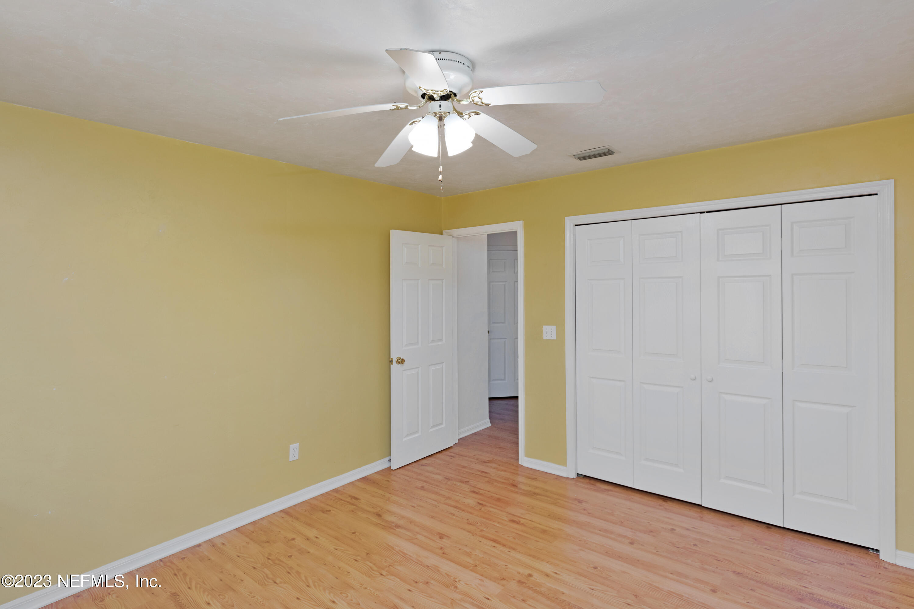 445 Southeast 28th Loop Melrose, FL 32666 - Photo 42 of 75 a view of an empty room with wooden floor and a ceiling fan