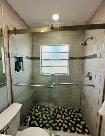 a bathroom with a sink a toilet a shower and mirror