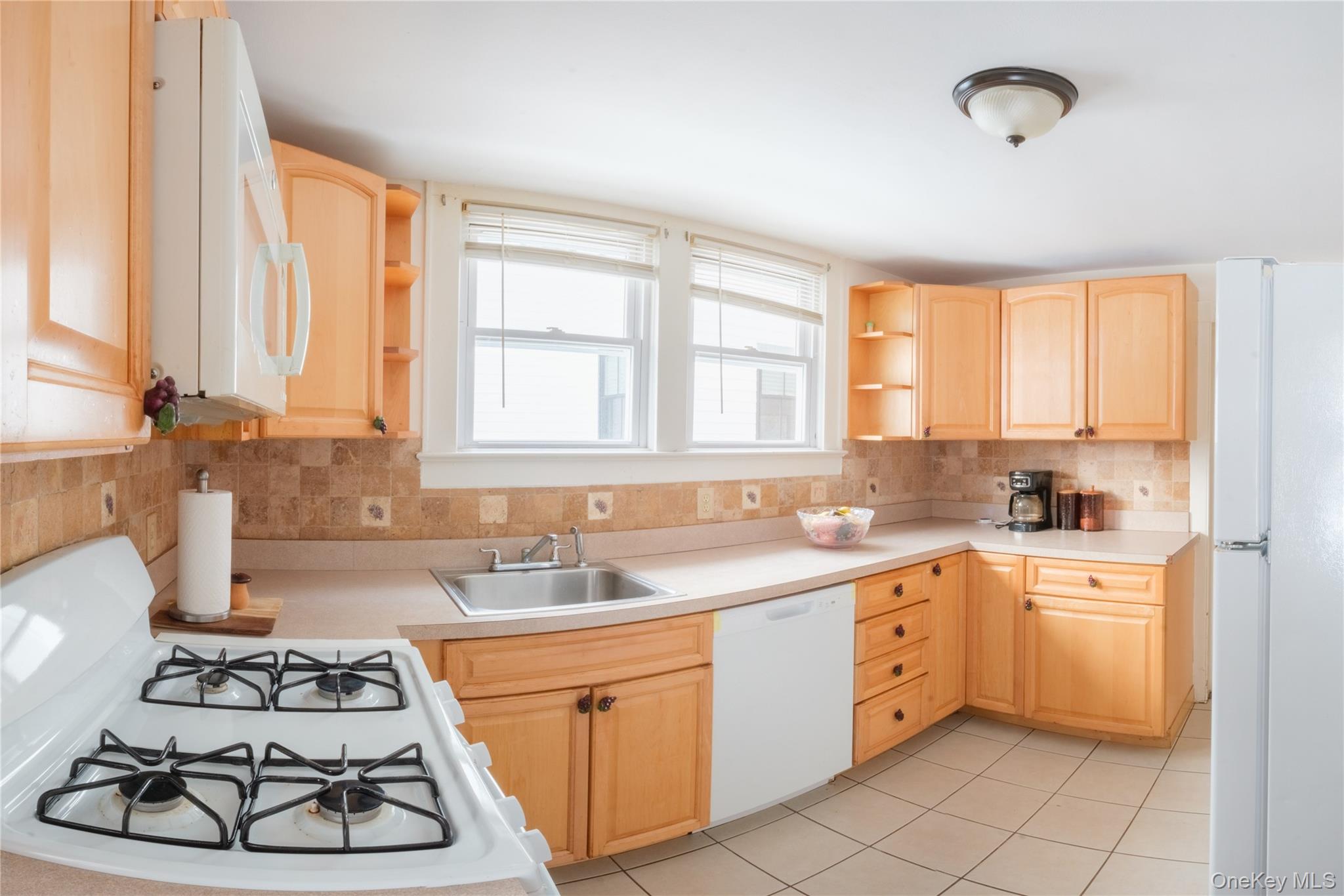 925 Constant Avenue Peekskill, NY 10566 - Photo 4 of 26 Kitchen featuring open shelves, light wood finish cabinetry, white appliances, light countertops, and tasteful backsplash