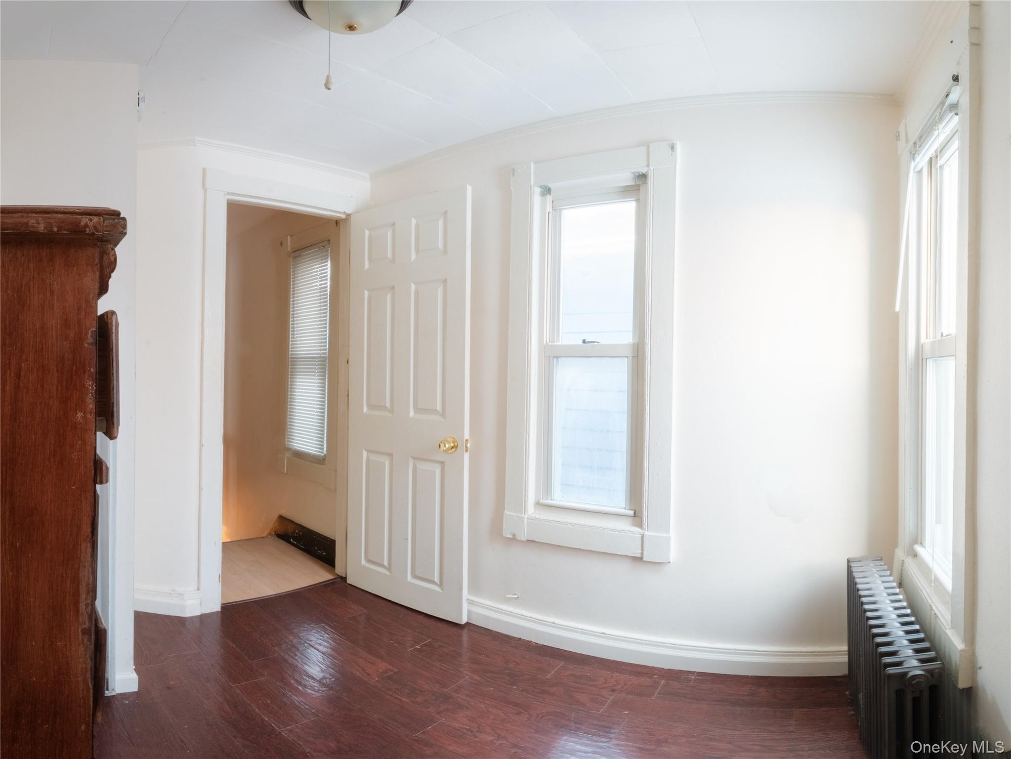 925 Constant Avenue Peekskill, NY 10566 - Photo 5 of 26 Unfurnished room with radiator and dark wood-style flooring