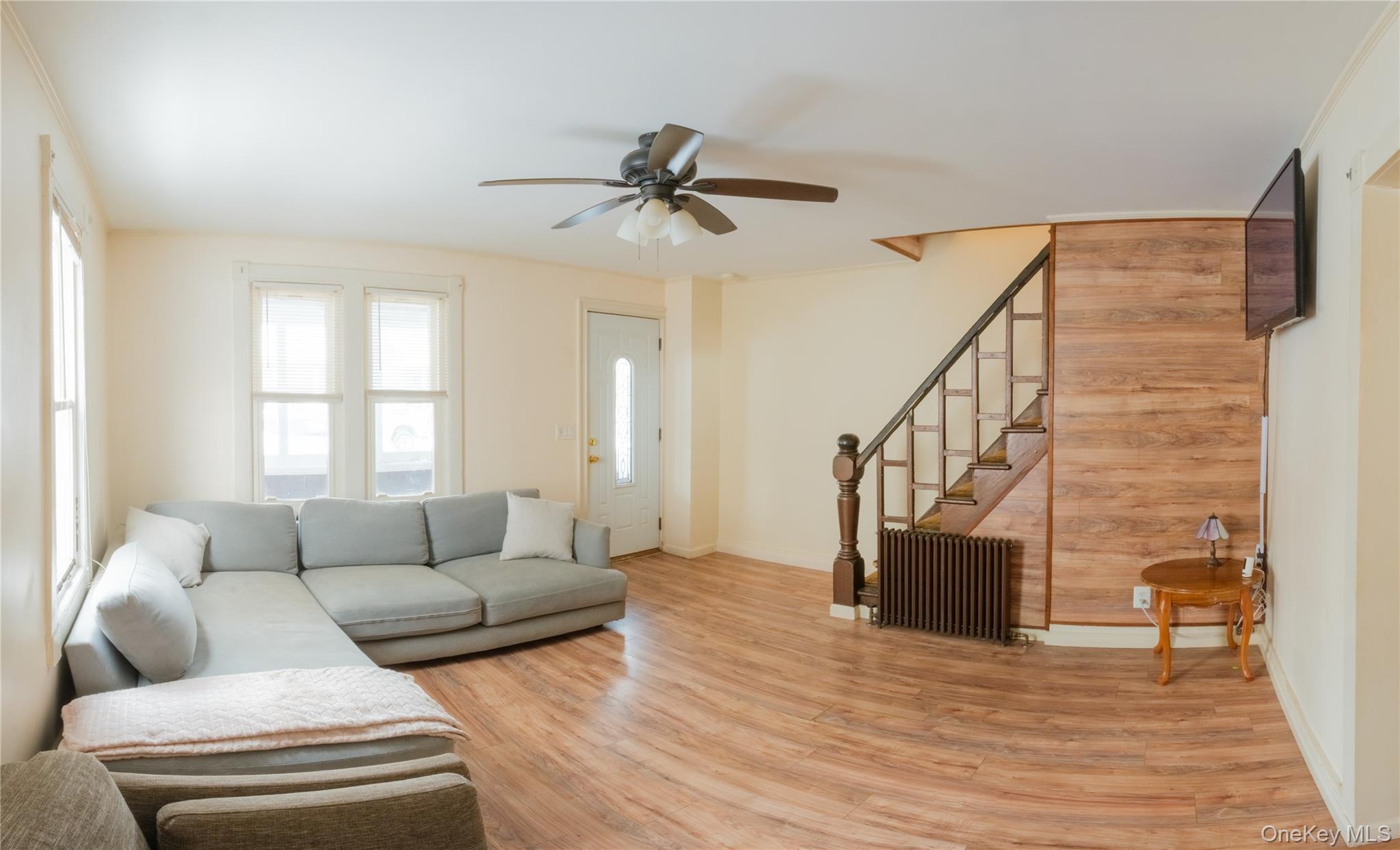 925 Constant Avenue Peekskill, NY 10566 - Photo 5 of 28 Living area featuring light wood finished floors, a ceiling fan, and wood walls