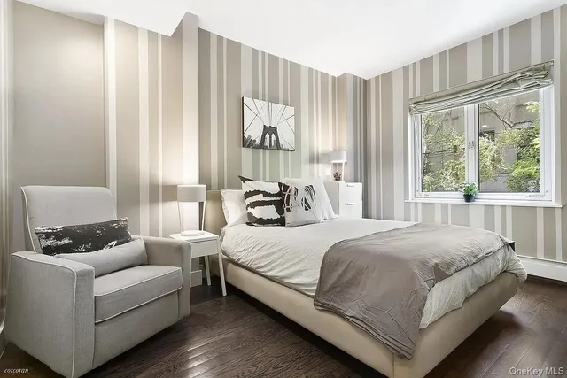 a bedroom with a bed couch and a large window