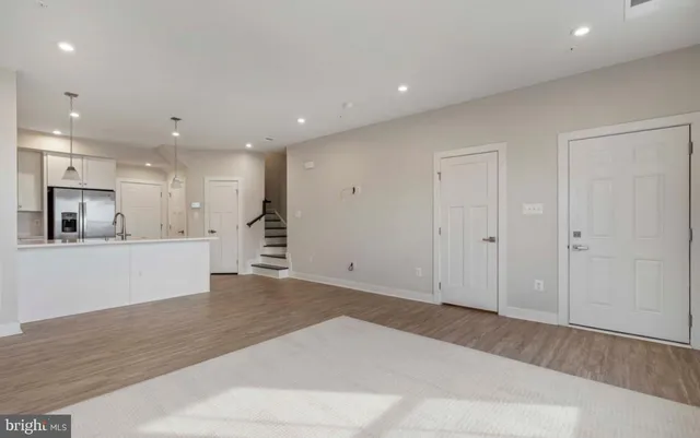 a view of kitchen with kitchen island white cabinets and wooden floor