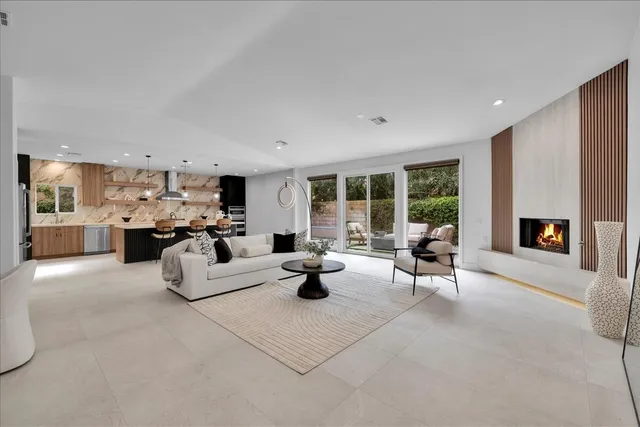 a large white kitchen with a large island in the center