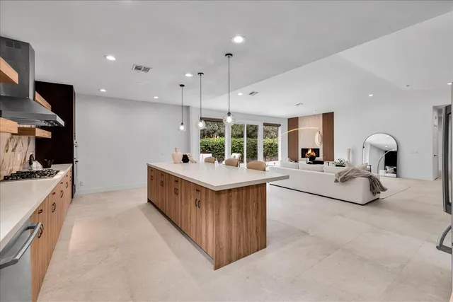 a kitchen with stainless steel appliances a refrigerator a sink a stove and white cabinets