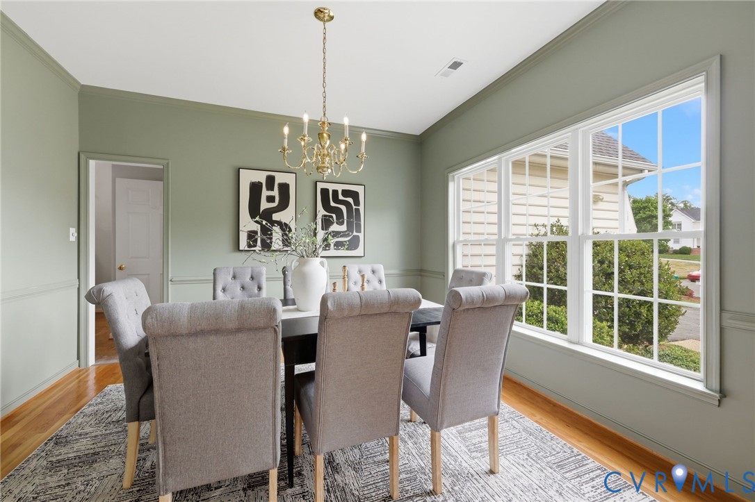 1700 Rolfield Way Henrico, VA 23238 - Photo 16 of 44 a dining room with furniture a chandelier and wooden floor
