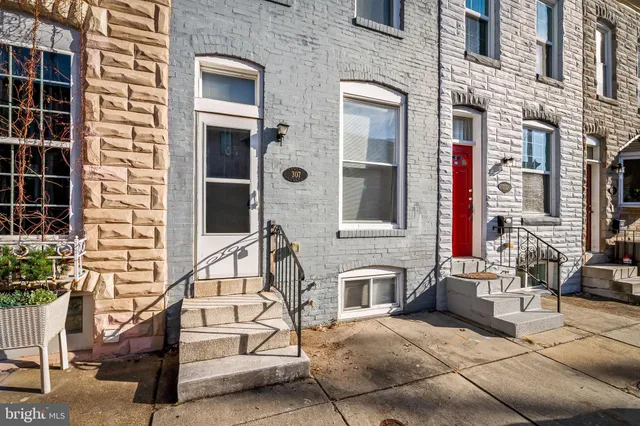a house with a bench in front of a brick building