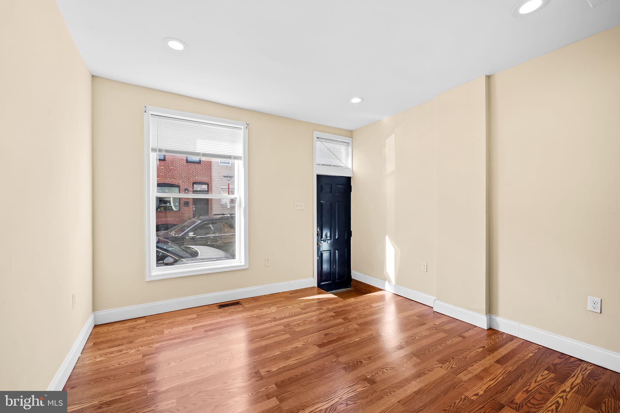 307 Fagley Street Baltimore, MD 21224 - Photo 4 of 24 an empty room with wooden floor and windows
