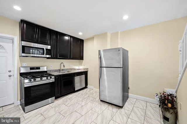 a kitchen with a refrigerator a stove and wooden cabinets