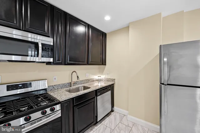a kitchen with stainless steel appliances granite countertop a stove and a refrigerator