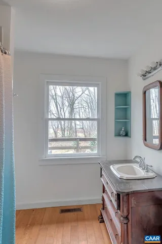 a bathroom with a sink a mirror and a window