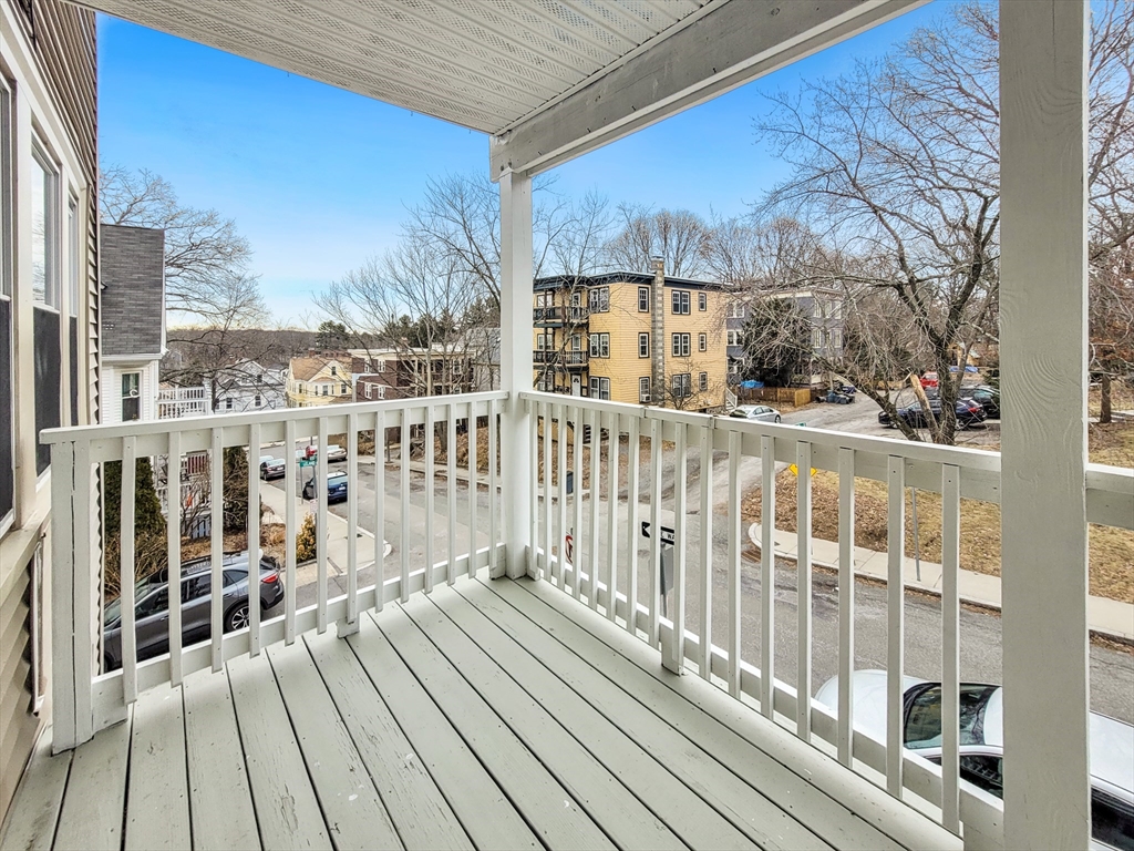 37-39 Juniper Street, Unit 39 1 Boston, MA 02119 - Photo 12 of 12 a view of a balcony with wooden floor and fence