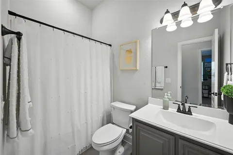 a bathroom with a sink vanity mirror and toilet
