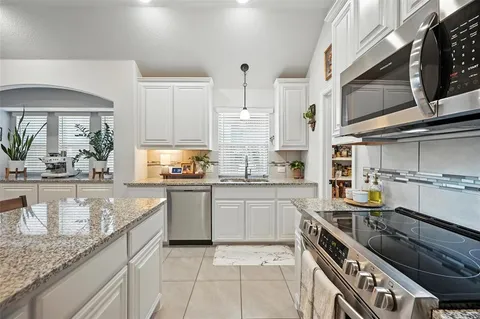 a kitchen with stainless steel appliances granite countertop a sink stove and cabinets