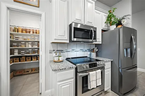 a kitchen with stainless steel appliances granite countertop a refrigerator stove and microwave
