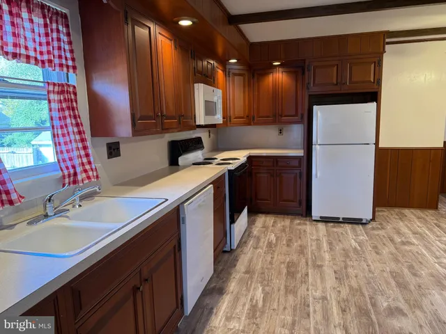 a kitchen with a sink cabinets stainless steel appliances and a window