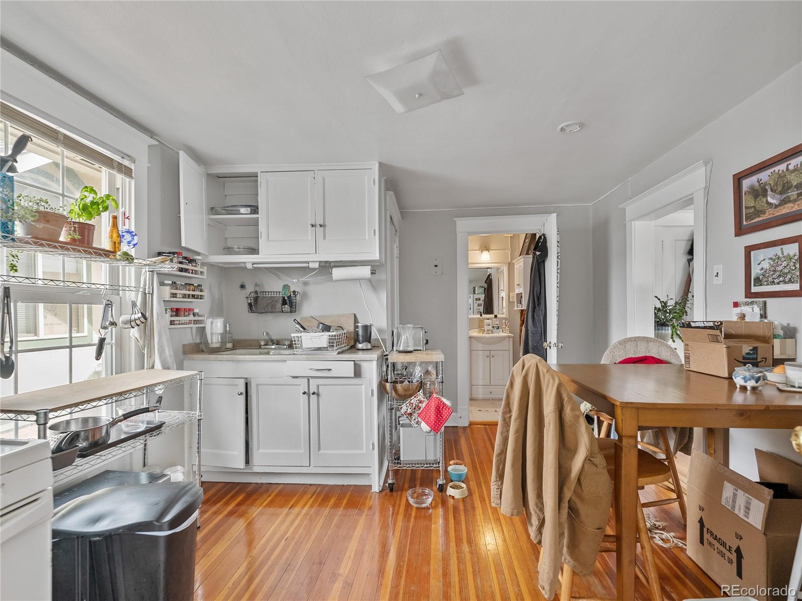 Undisclosed Address Denver, CO 80206 - Photo 13 of 33 a kitchen that has a lot of cabinets in it and wooden floors