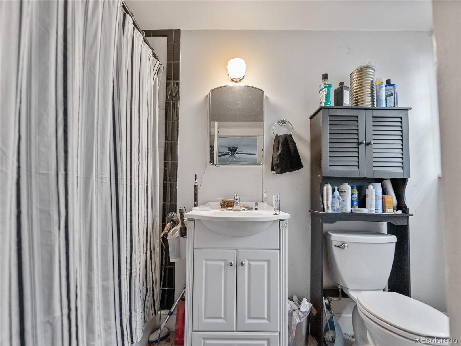 Undisclosed Address Denver, CO 80206 - Photo 16 of 33 a bathroom with a toilet a sink and a mirror