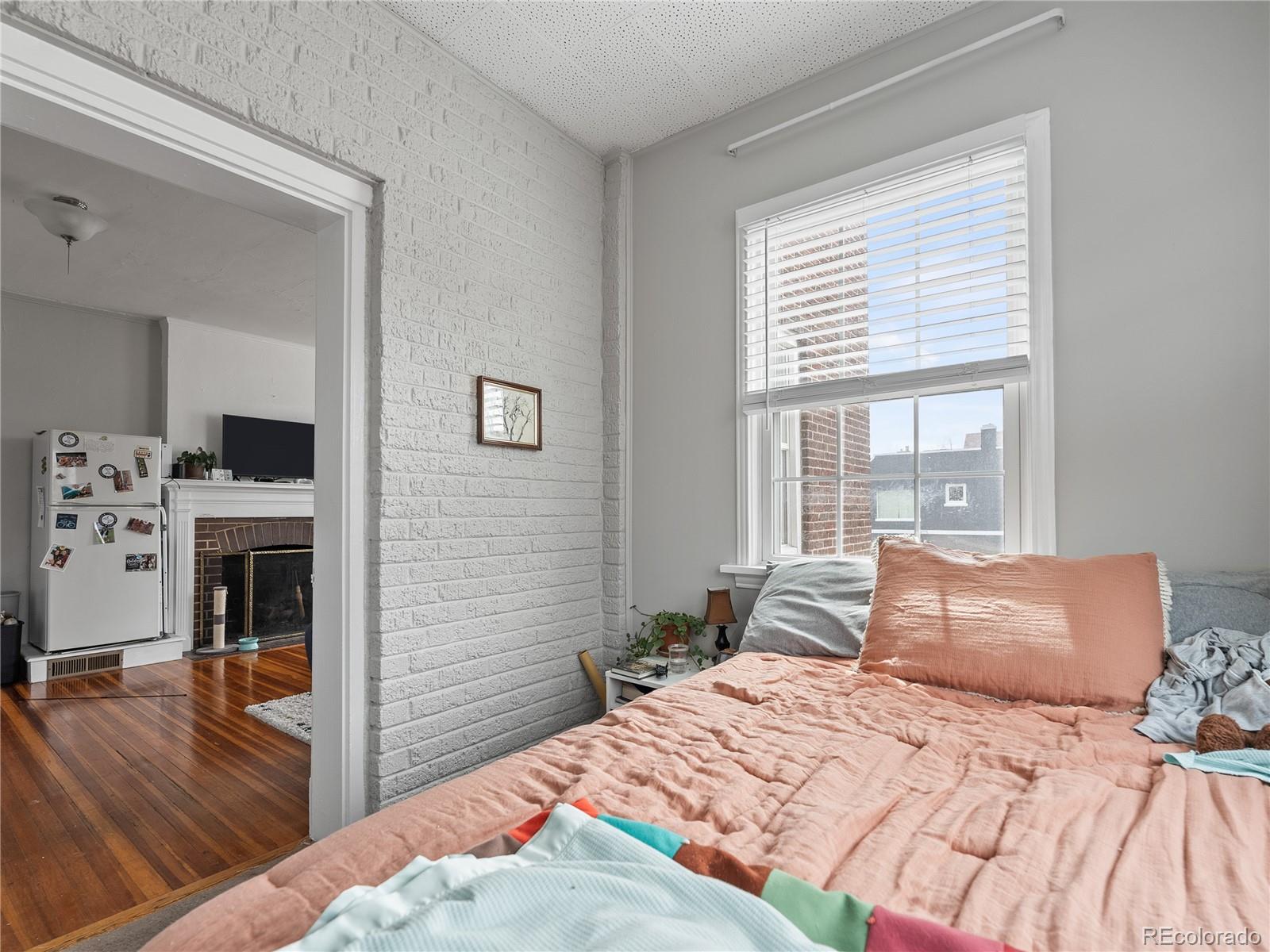 Undisclosed Address Denver, CO 80206 - Photo 24 of 33 a bedroom with a bed and a flat tv screen on the dresser