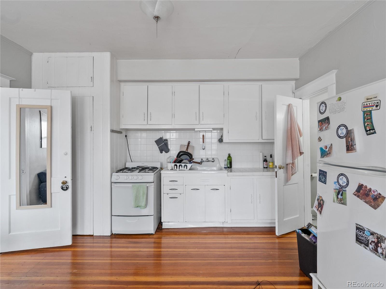 Undisclosed Address Denver, CO 80206 - Photo 9 of 33 a kitchen with white cabinets and white appliances