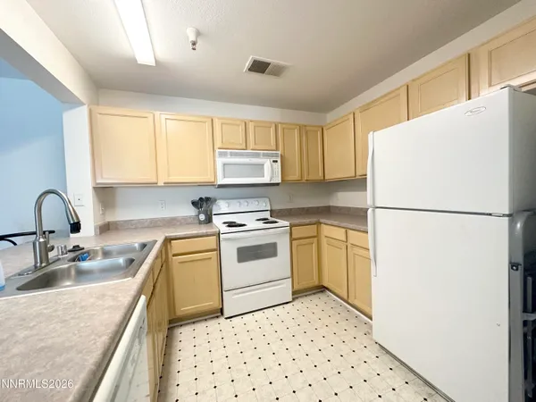 a kitchen with a refrigerator sink and cabinets