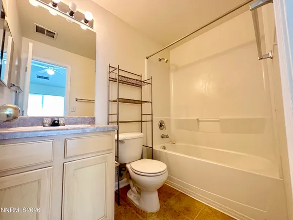 a bathroom with a toilet sink vanity and shower