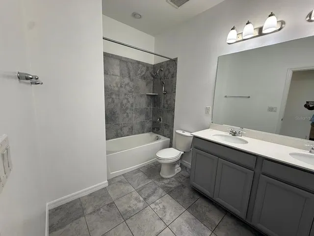 a bathroom with a bathtub shower sink mirror vanity and toilet